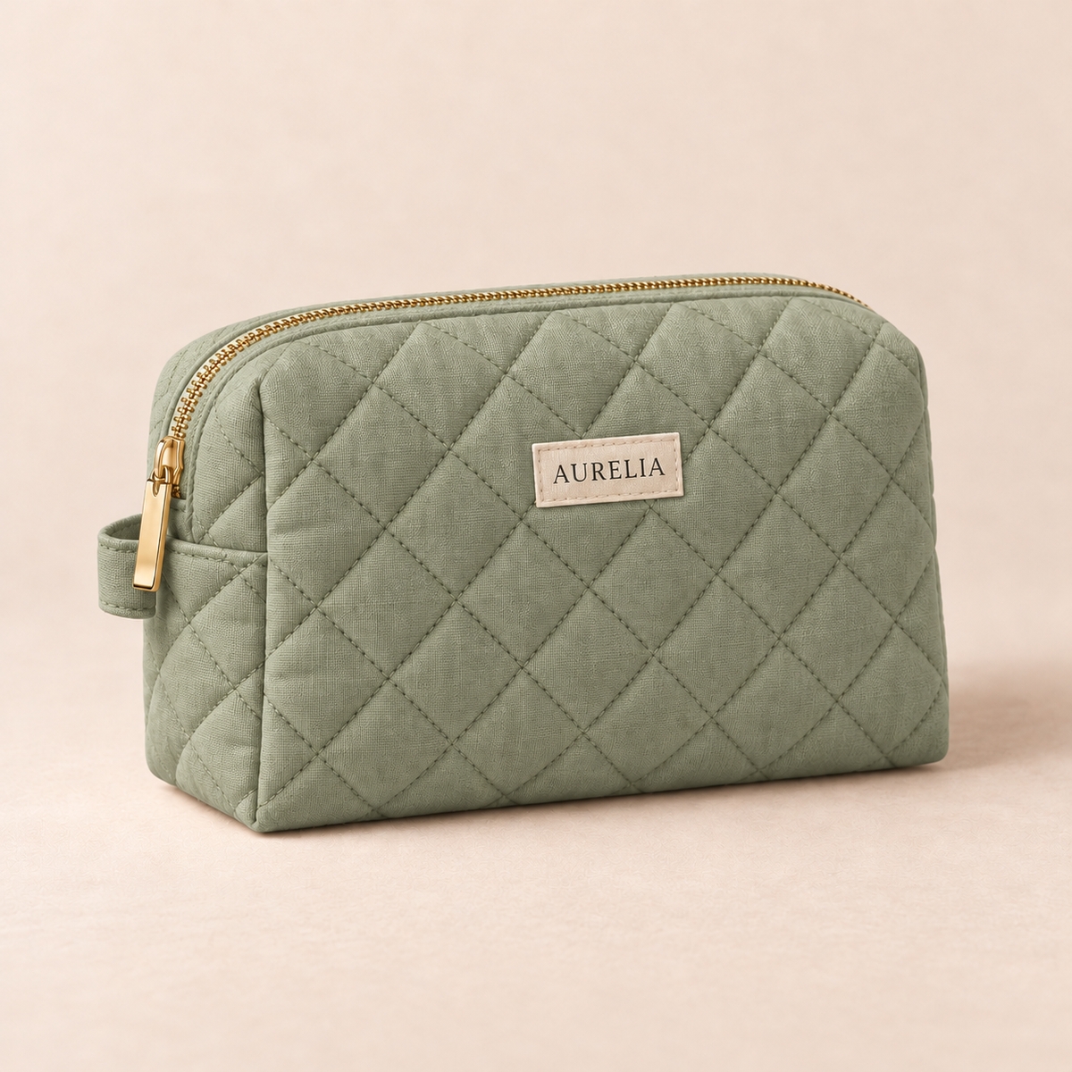 Aurelia Botanicals Quilted Cosmetic Bag in Sage on a warm beige background.